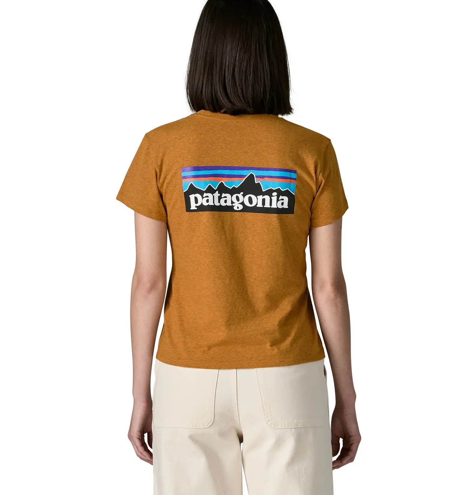 Woman wearing the Patagonia women's P-6 logo responsibili-tee short sleeved t-shirt in dried mango yellow showing the large logo on the back. 