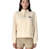 A woman wearing a cream Patagonia Women's Ahnya Pullover showing 1/4 length front zip.
