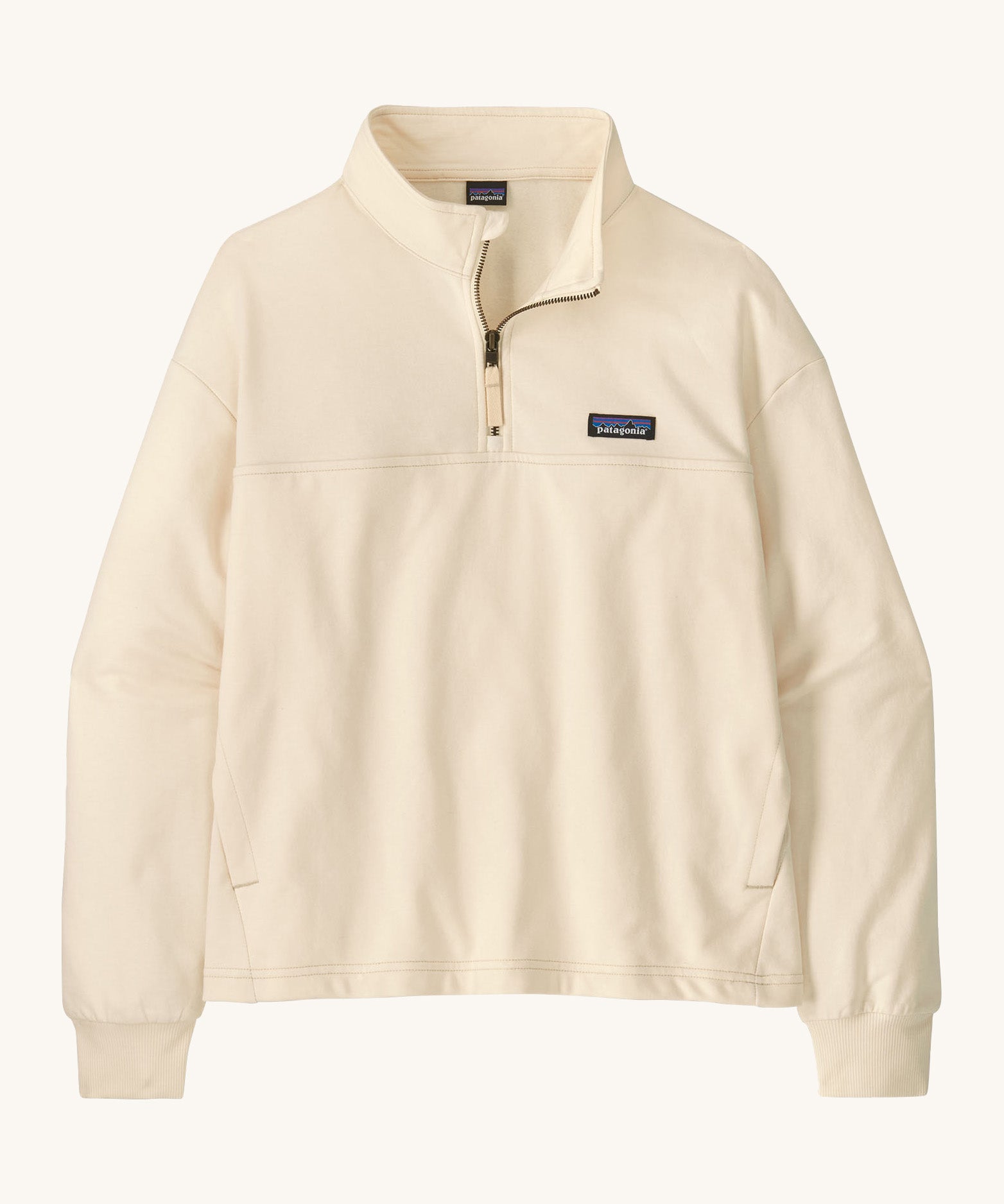 Patagonia women's Anya pullover. A cream lightweight pullover, features a 1/4 length zip, easy access side pockets and the logo patch stitched on the left chest.