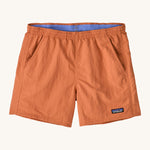 Patagonia women's baggies short in a light orange colour on a cream background.