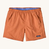Patagonia women's baggies short in a light orange colour on a cream background.