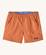 Patagonia women's baggies short in a light orange colour on a cream background.