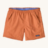 Patagonia women's baggies short in a light orange colour on a cream background.