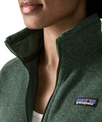 Woman wearing the Patagonia women’s better sweater fleece jacket in green. Close up of collar with zip open.