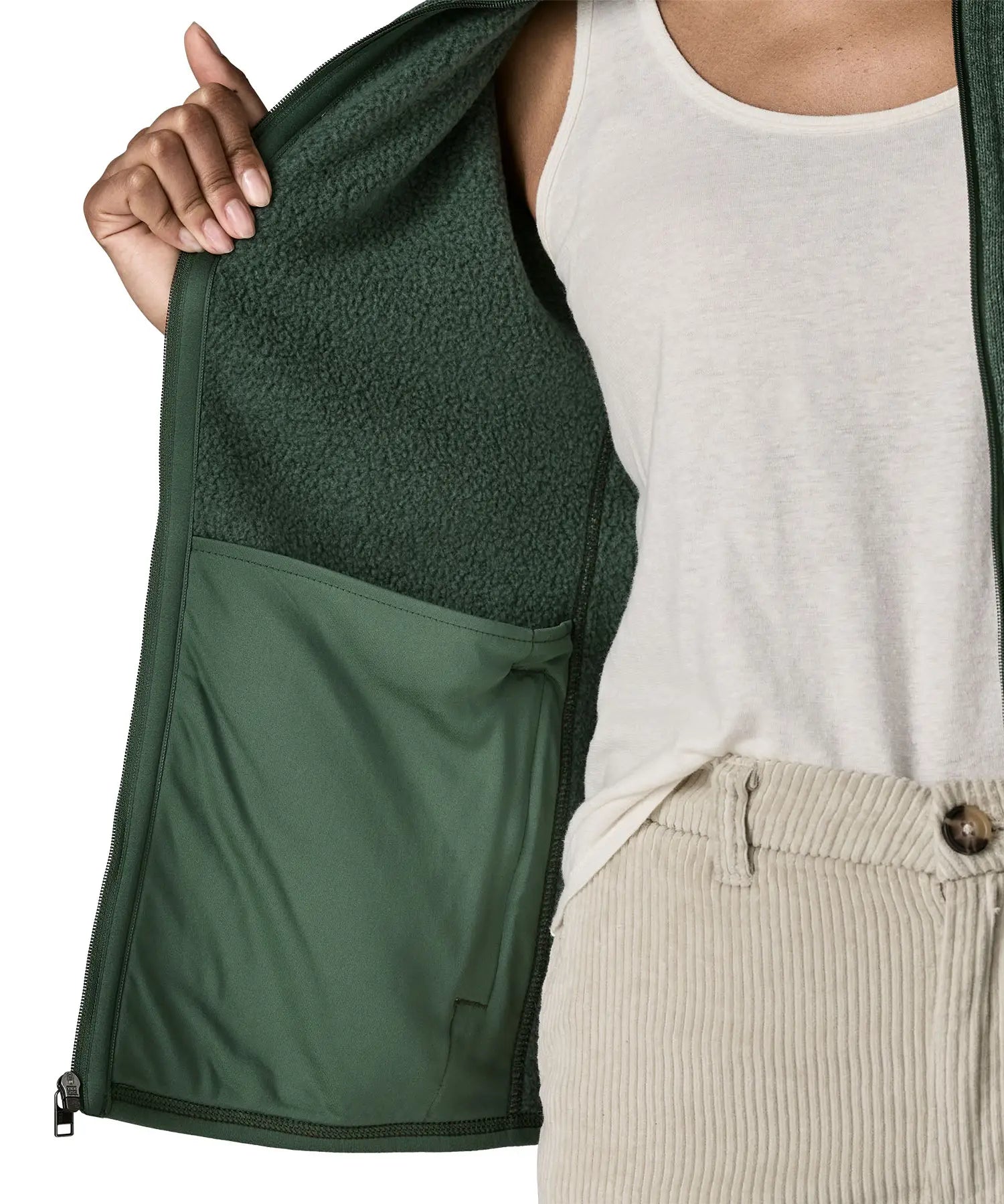 Woman wearing the Patagonia women’s better sweater fleece jacket in green holding the jacket open showing inside of pocket.