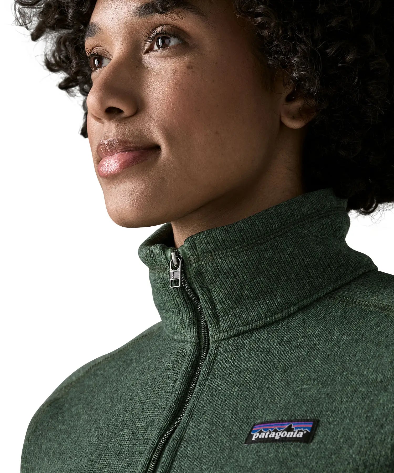 Woman wearing the Patagonia women’s better sweater fleece jacket in green. Close up of collar with zip closed.