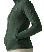 Side of woman wearing the Patagonia women’s better sweater fleece jacket in green. Full zip jacket with zipped arm pocket and handwarmer pockets.