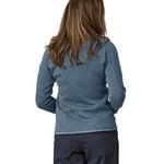 A woman wearing a Patagonia Women's Better Sweater Jacket Utility Blue stood in front of a plain background showing the back of the jacket