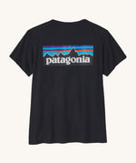 Patagonia women's short sleeve top in black showing the large logo printed on back