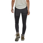 Woman stood backwards on a white background wearing the Patagonia eco-friendly pack out hiking leggings