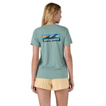 The back of a woman wearing the Patagonia Women's Cap Cool Daily Graphic Shirt in a Waters Thermal Blue colour available at Babipur 