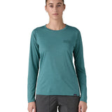 Patagonia women's long sleeve capilene top in turquoise mountain outline design worn by a woman