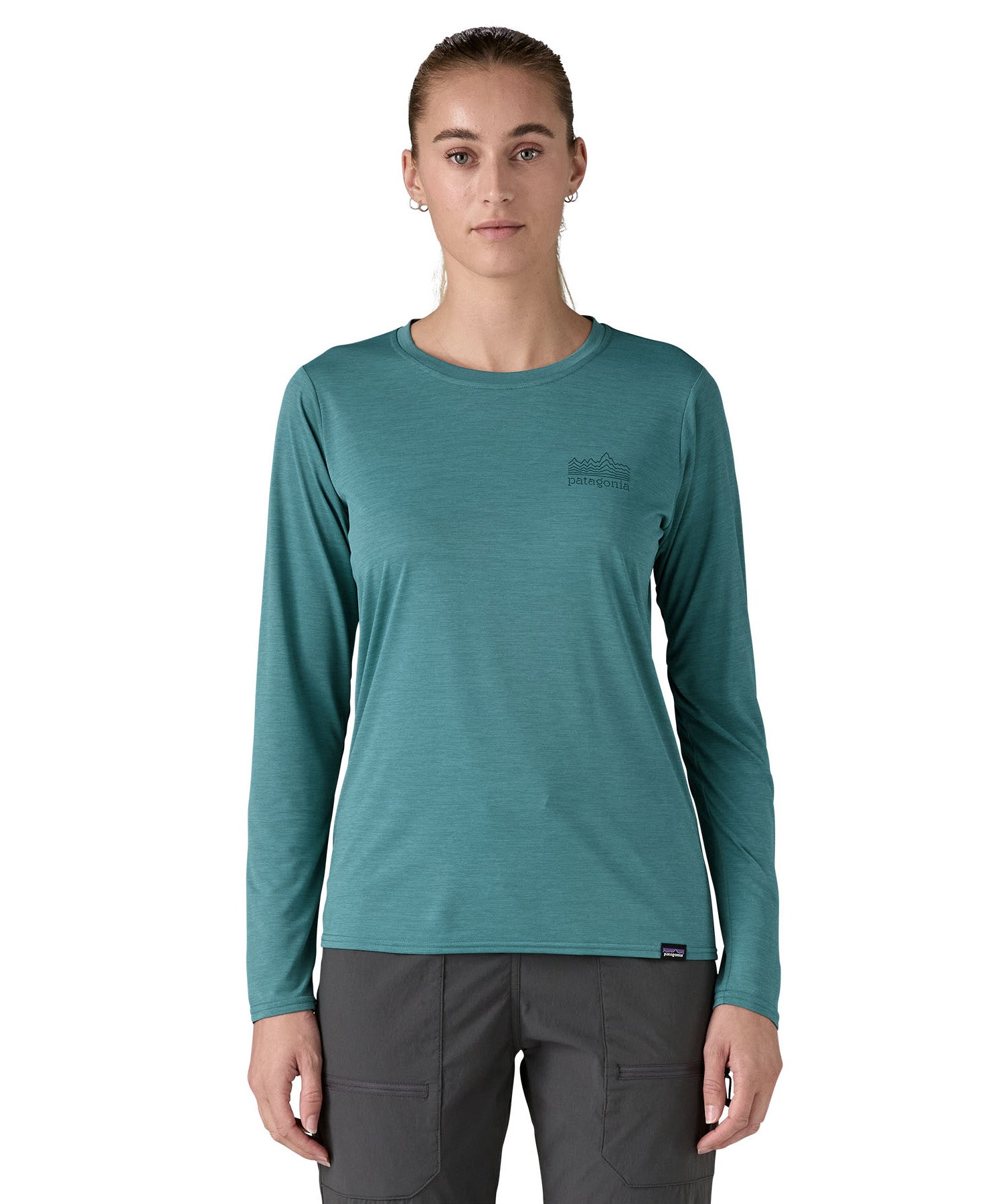 Patagonia women's long sleeve capilene top in turquoise mountain outline design worn by a woman