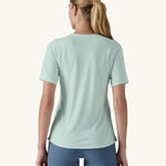 Patagonia Women's Capilene Cool Trail Graphic Shirt in a Wispy Green colour. She is facing away from the camera. 