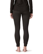 Back of woman wearing the Patagonia women's Capilene midweight bottoms black. Fitted leggings sitting on the ankles. 