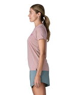 Woman wearing the Patagonia women's capilene t-shirt in violet that sits below the hips with a small black logo tag on the hem.