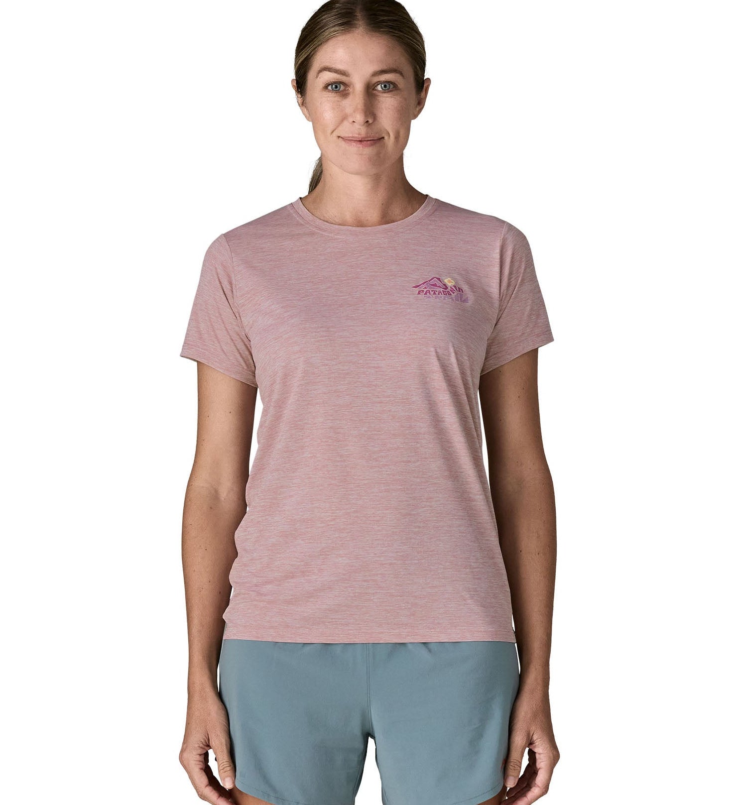 Woman wearing the Patagonia women's capilene t-shirt in violet with small pink trailcheck graphic on the chest.