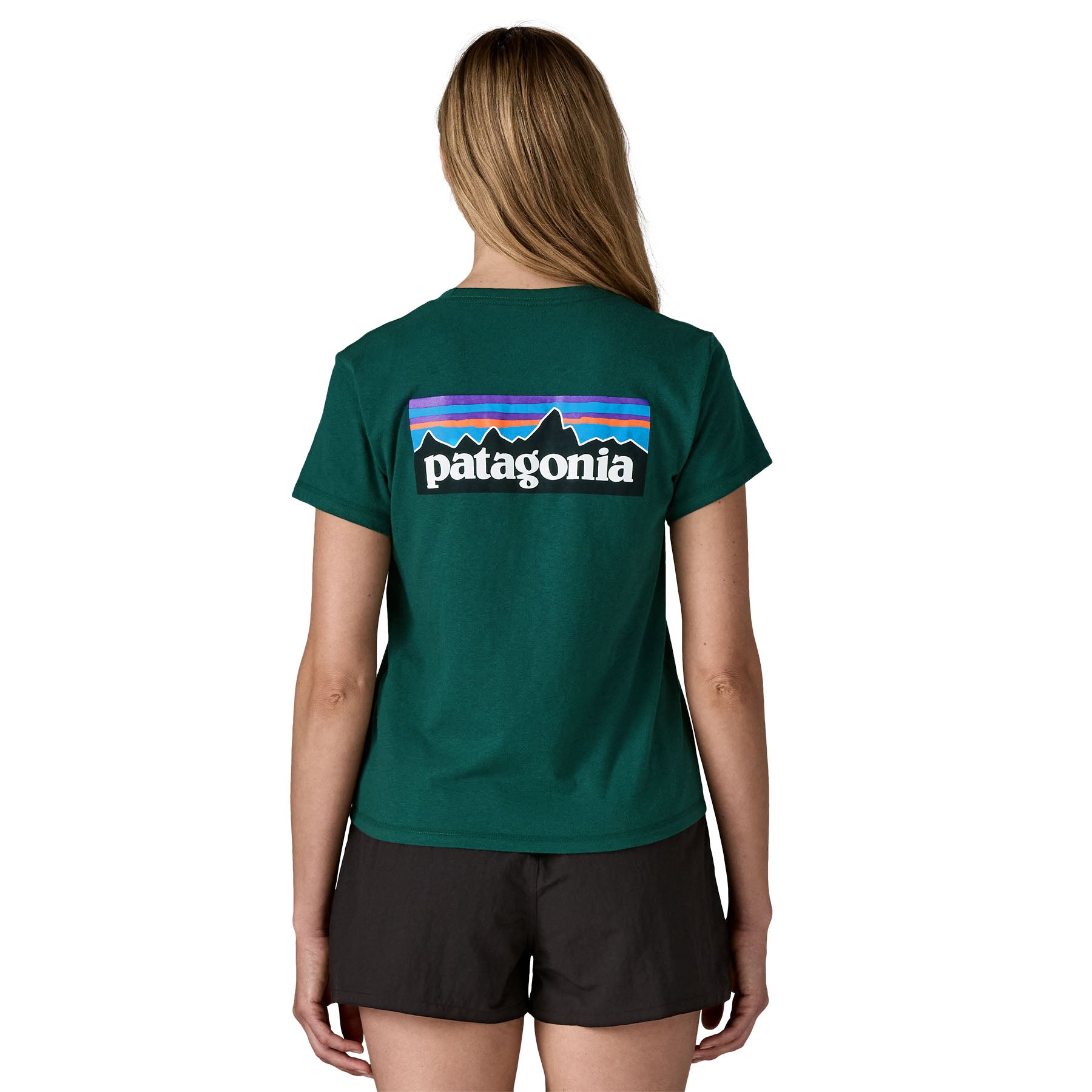 A woman wearing the Patagonia cascade green short sleeve shirt showing the large brand logo printed on the back of the t-shirt