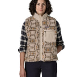 Woman waering the Patagonia women's classic Retro-X® fleece vest with a snowshoe hare pattern on natural. Full zip up front with zipped handwarmer pockets and zipped chest pocket.