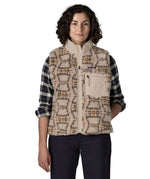 Woman waering the Patagonia women's classic Retro-X® fleece vest with a snowshoe hare pattern on natural. Full zip up front with zipped handwarmer pockets and zipped chest pocket.