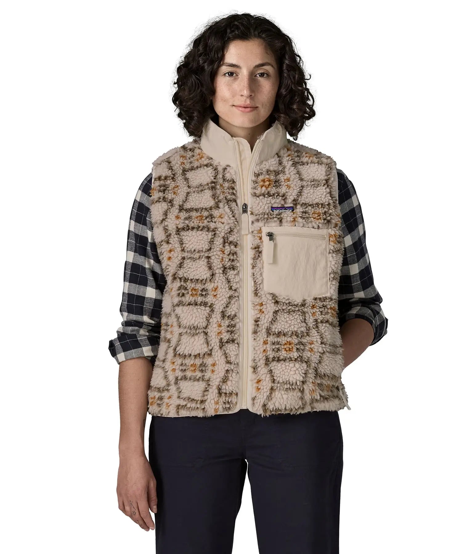 Woman waering the Patagonia women's classic Retro-X® fleece vest with a snowshoe hare pattern on natural. Full zip up front with zipped handwarmer pockets and zipped chest pocket.
