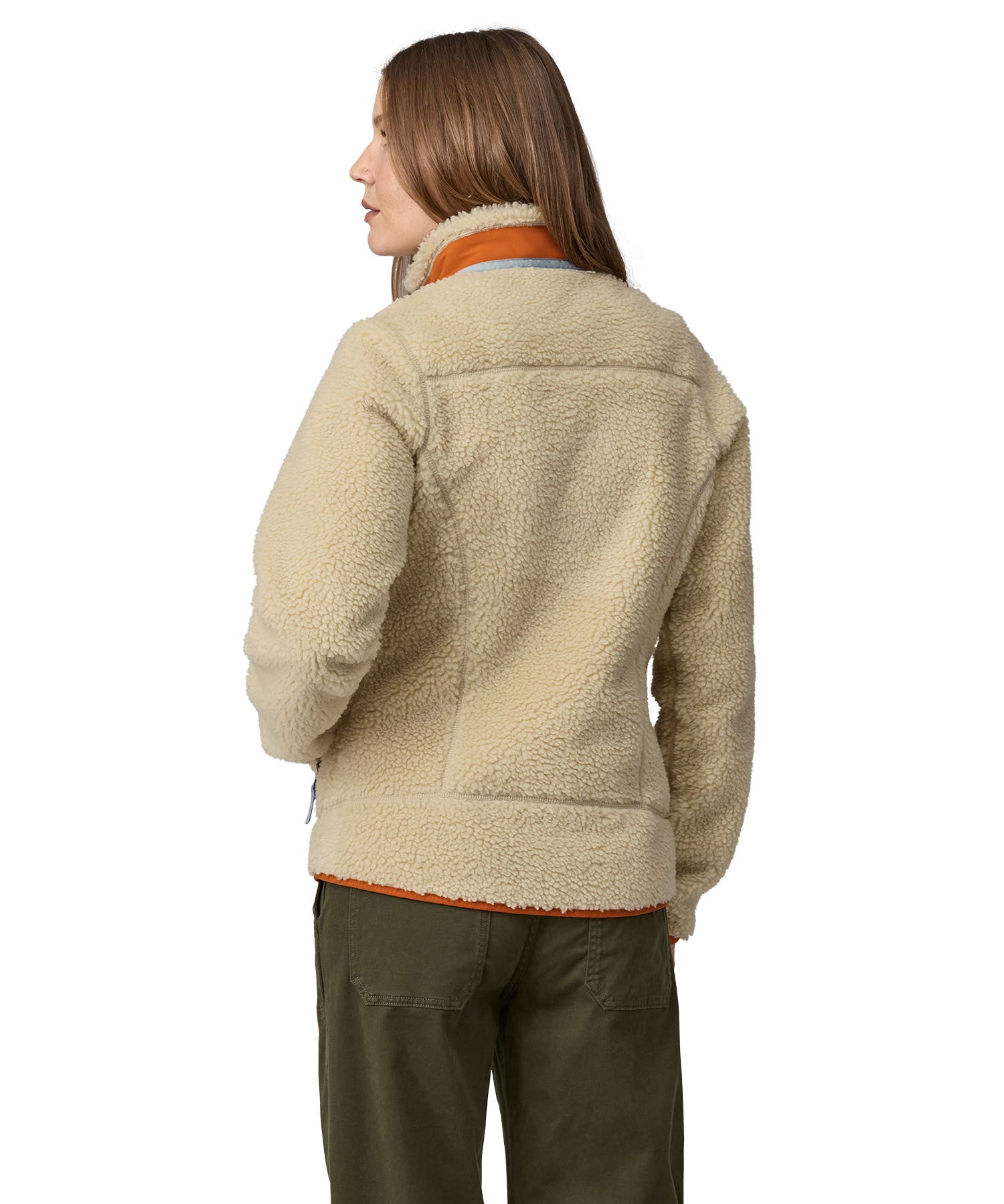 A woman wearing a Patagonia Women's Classic Retro-X Jacket in a Dark Natural colour standing against a plain background, showing the back of the jacket.