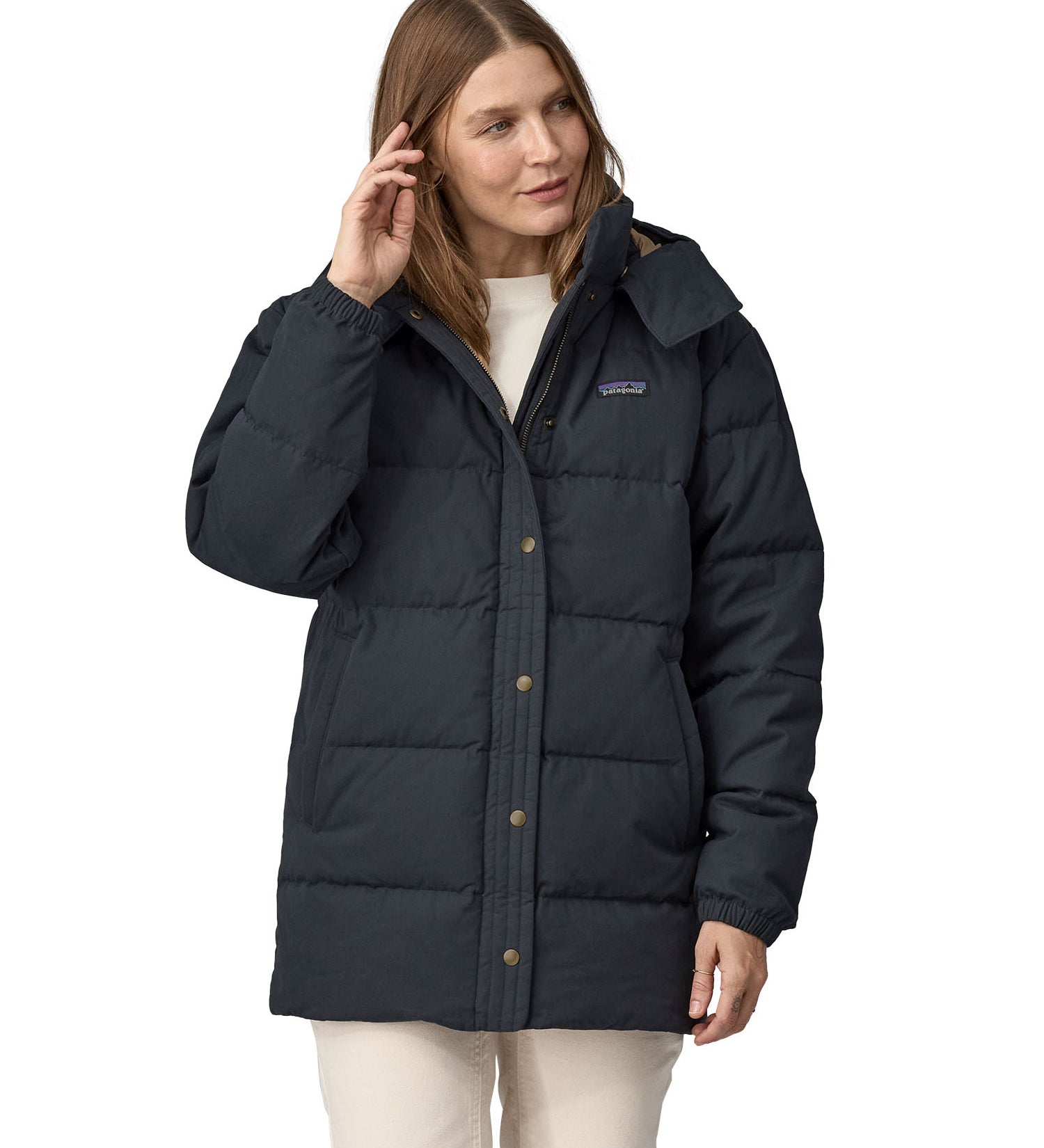 A woman wearing the Patagonia Women's Cotton Down Parka - Pitch Blue.