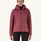 A women wearing the Patagonia Women's Down Insulated Sweater Hoody in a Marion Red colour. 
