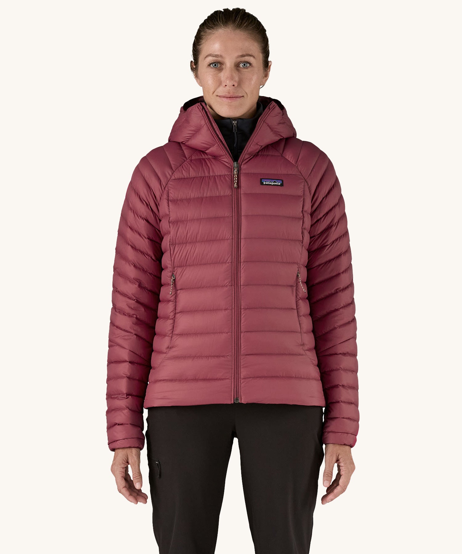 A women wearing the Patagonia Women's Down Insulated Sweater Hoody in a Marion Red colour. 
