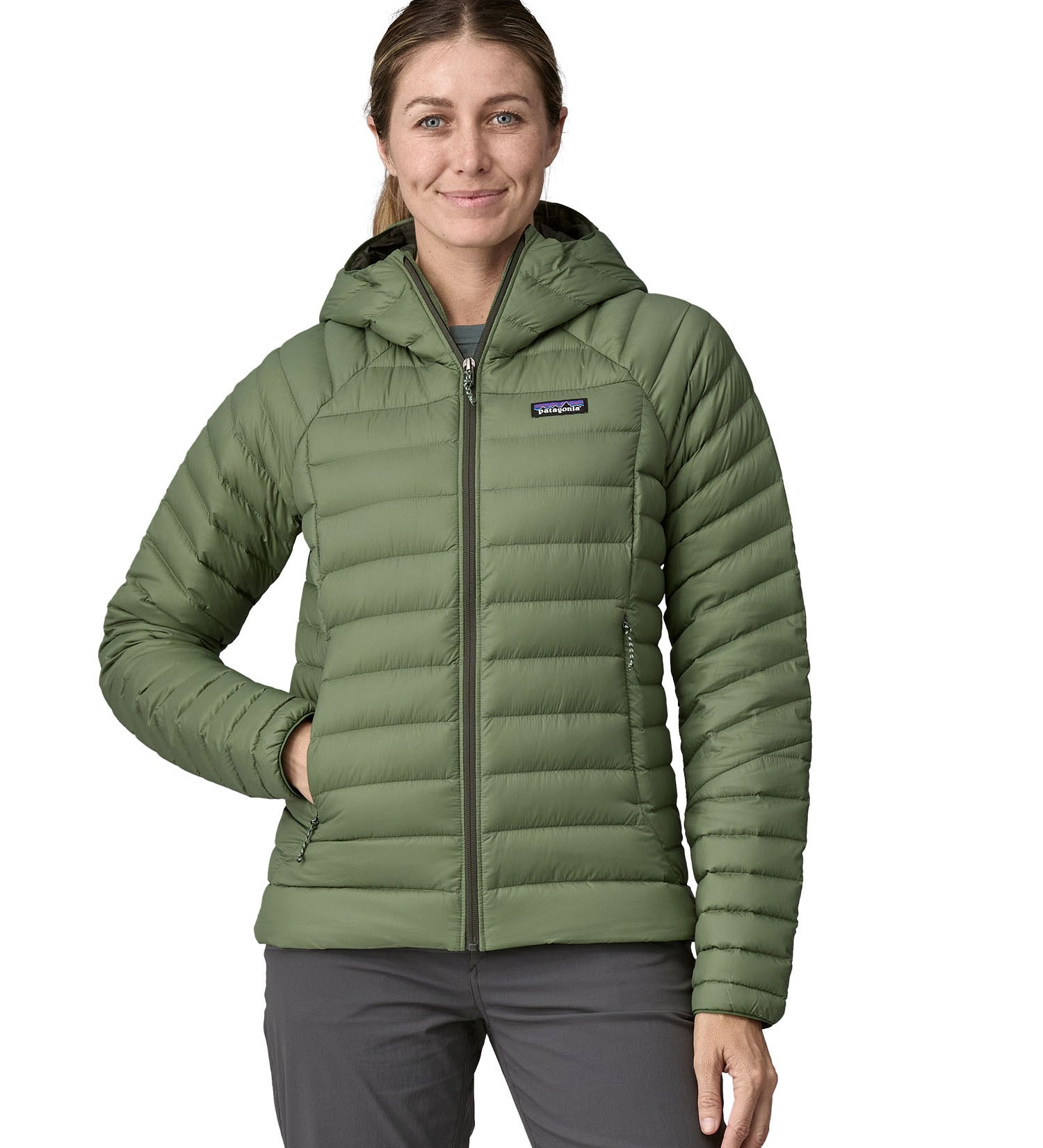 A woman wearing a Patagonia Women's Down Sweater Hoody in terrain green.
