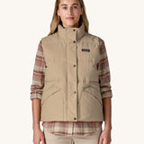 A woman wearing a beige coloured Patagonia Women's Downdrift Vest gilet. 