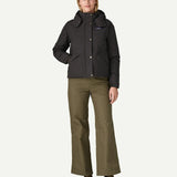 A woman wearing the Patagonia downdrift jacket in black, along with Patagonia cotton corduroy trousers.