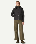 A woman wearing the Patagonia downdrift jacket in black, along with Patagonia cotton corduroy trousers.