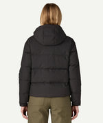 The back of the Patagonia women's Downdrift Jacket in black, worn by a model to showcase the fit. 