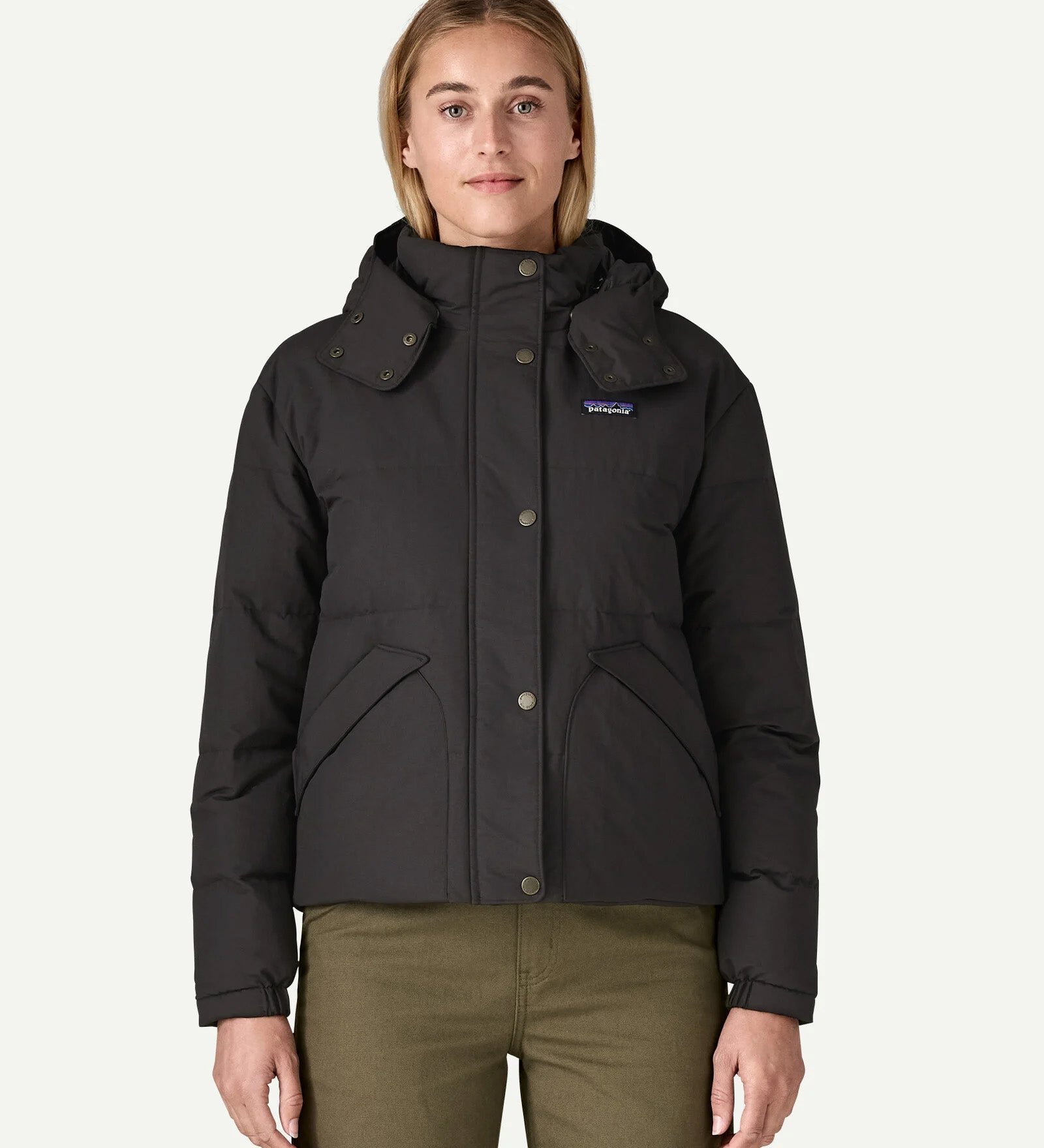 A woman wearing the Patagonia women's downdrift jacket in black to showcase the fit and recycled fabric.