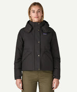 A woman wearing the Patagonia women's downdrift jacket in black to showcase the fit and recycled fabric.