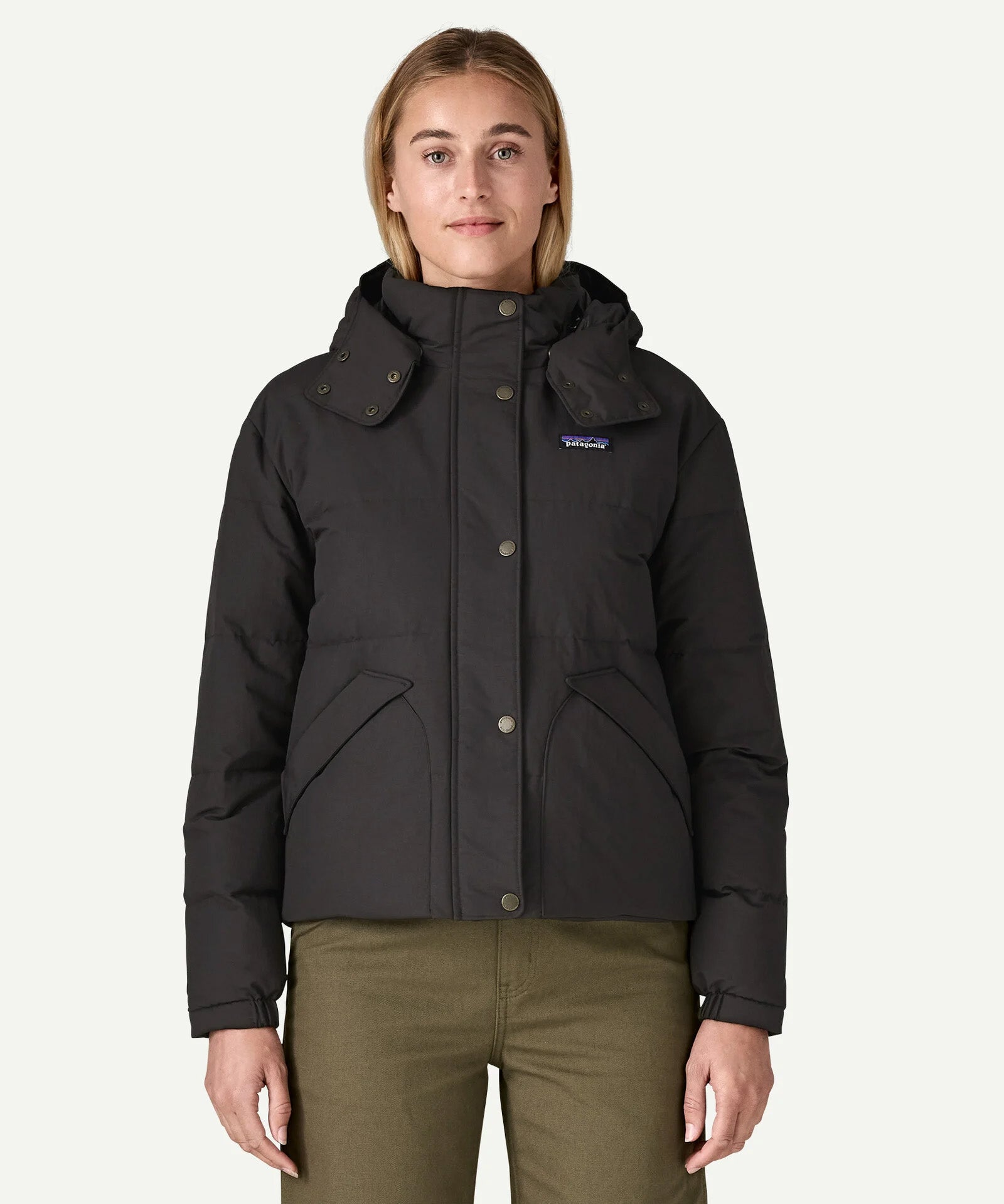A woman wearing the Patagonia women's downdrift jacket in black to showcase the fit and recycled fabric.