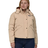 A woman with long light coloured hair wearing the Patagonia Women's Downdrift Jkt Oar Tan