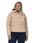 A woman with long light coloured hair wearing the Patagonia Women's Downdrift Jkt Oar Tan