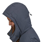 A side profile view close up of a person wearing the Patagonia Women's Downdrift Parka in Pine Smolder Blue showing the hood up 