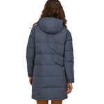 A view of the back of a woman wearing the Patagonia Women's Downdrift Parka in Pine Smolder Blue