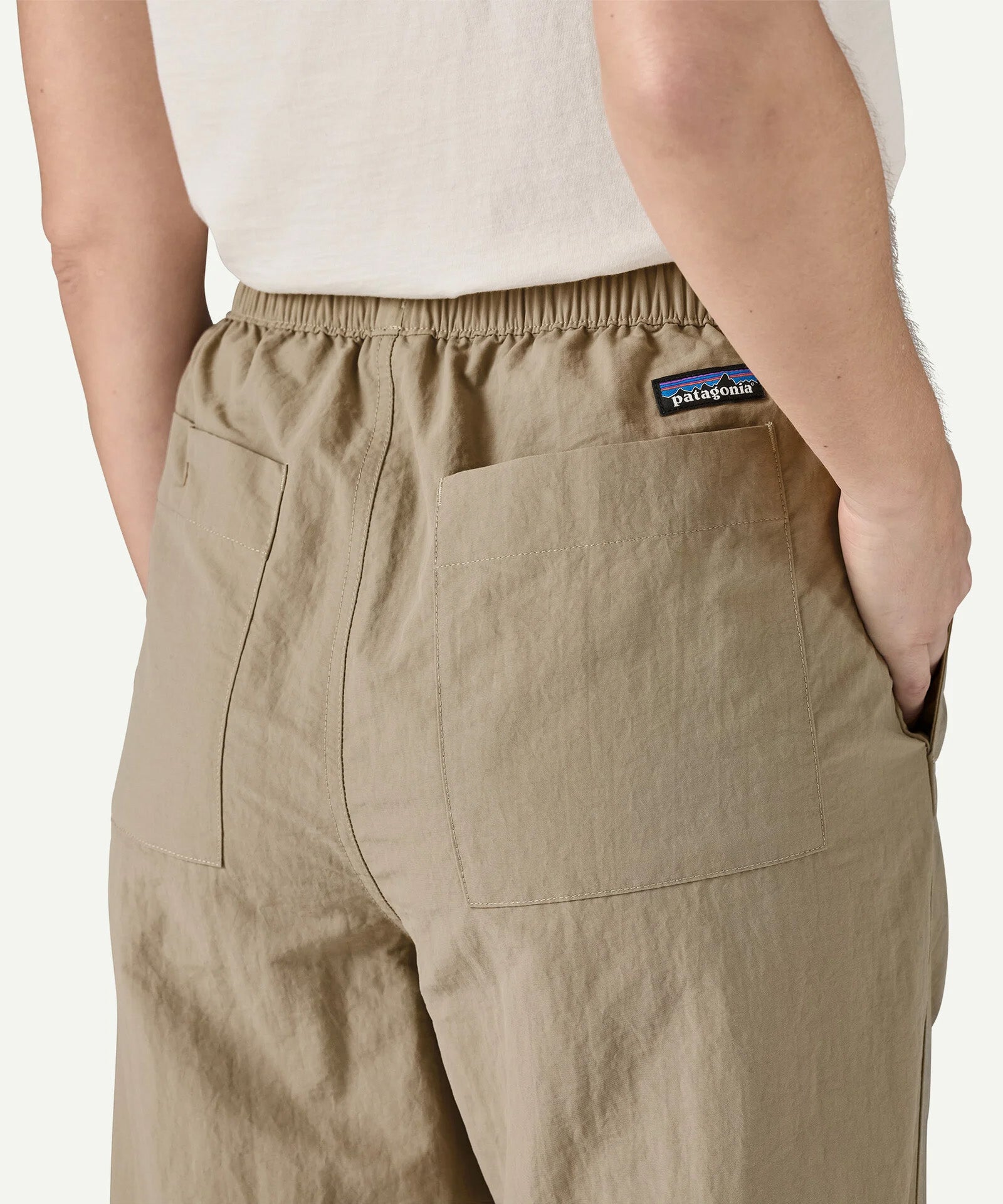 Angled back view of Patagonia Women’s Outdoor Everyday Pants in Seabird Grey, highlighting the elasticated waistband, rear patch pockets, and relaxed fit through the legs.