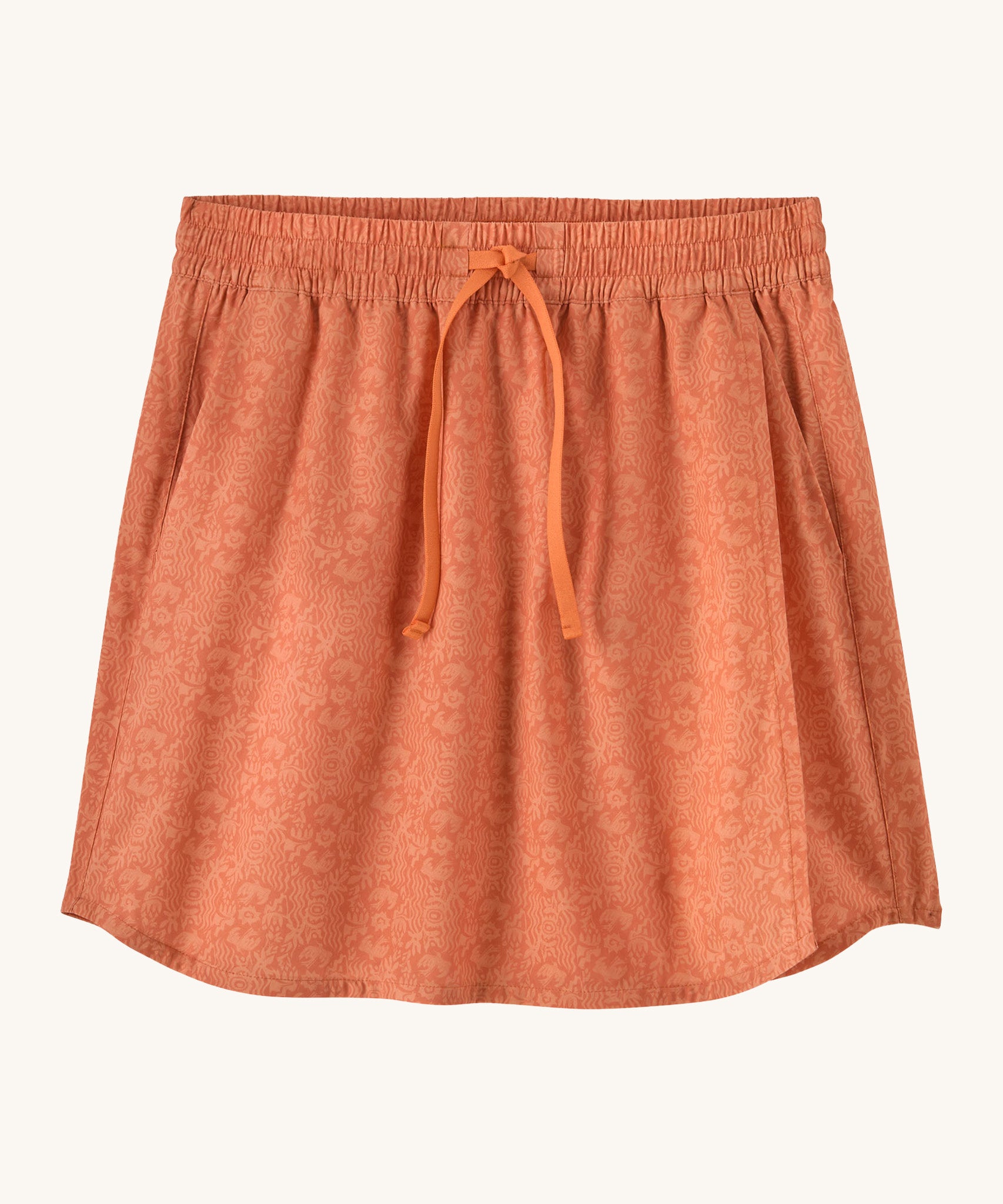 Patagonia women's fleetwith skort in a coral colour with flower design on a cream background.