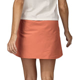 Patagonia women's fleetwith skort in a pastel orange colour worn by a woman back detail