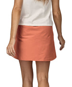 Patagonia women's fleetwith skort in a pastel orange colour worn by a woman back detail