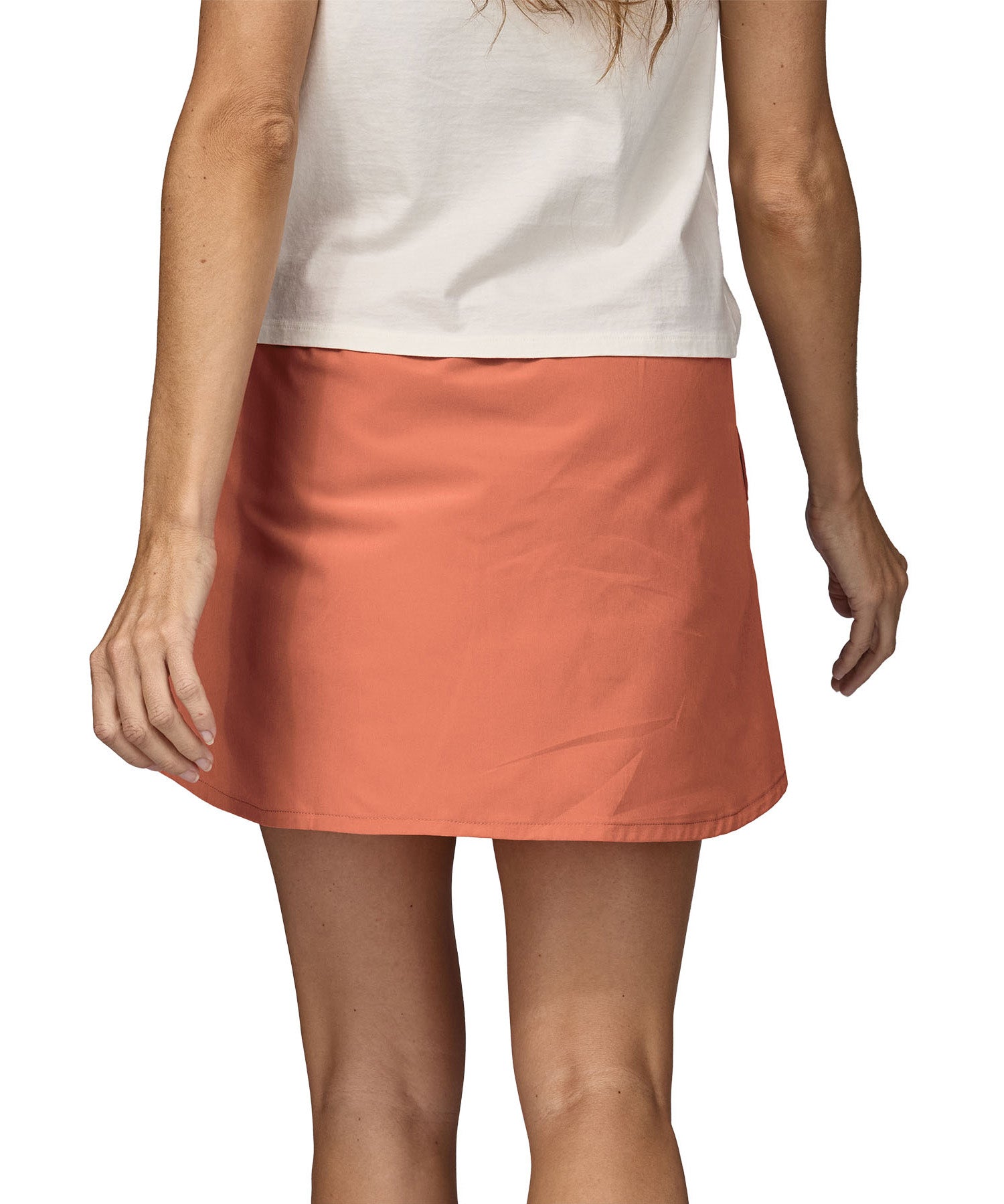 Patagonia women's fleetwith skort in a pastel orange colour worn by a woman back detail