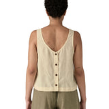 Woman wearing a Patagonia women's sleeveless garden island top in light cream whole weave material with the button up closure on the back.