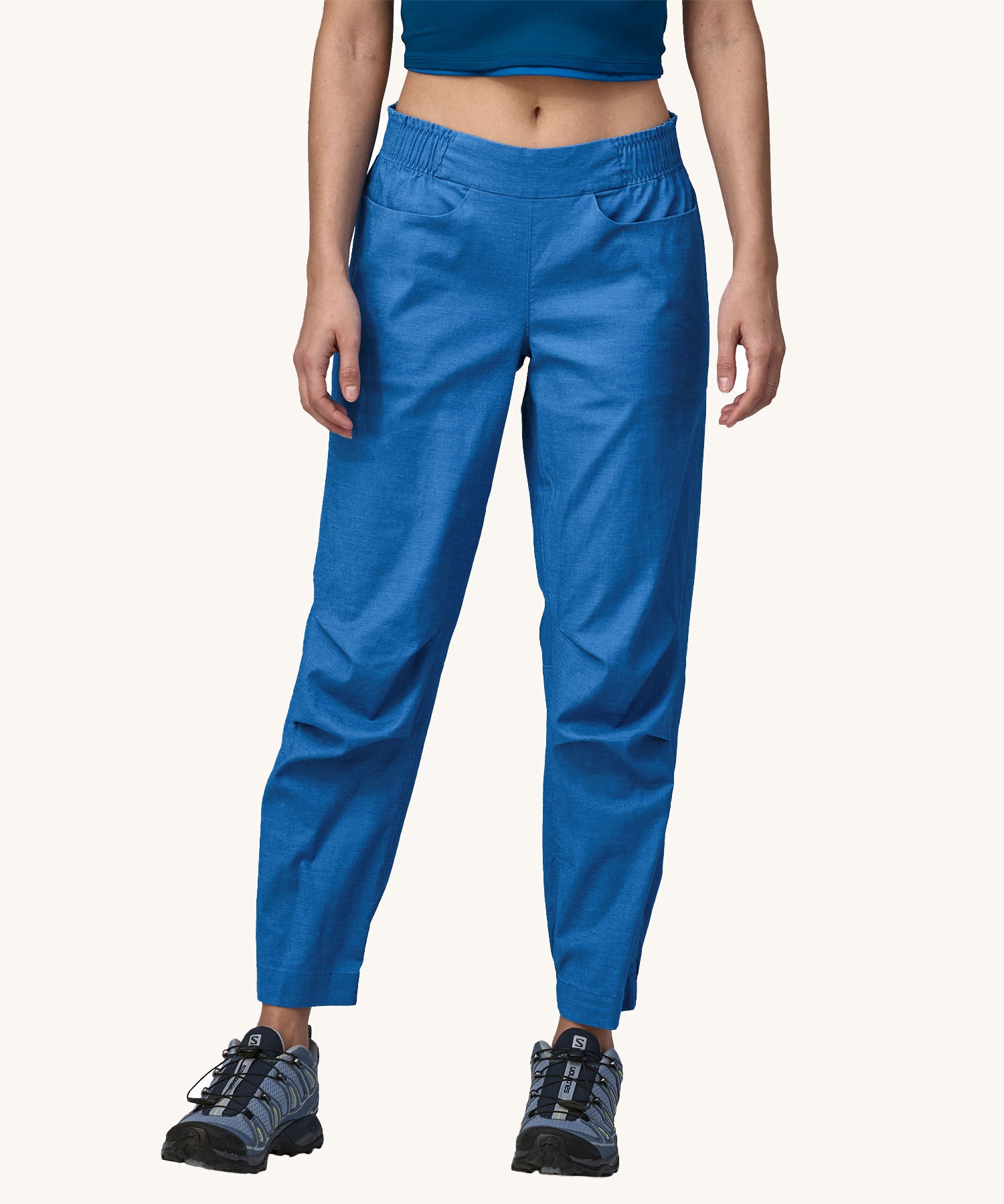 A person wearing a pair of Patagonia Women's Hampi Rock Pants in a blue colour.