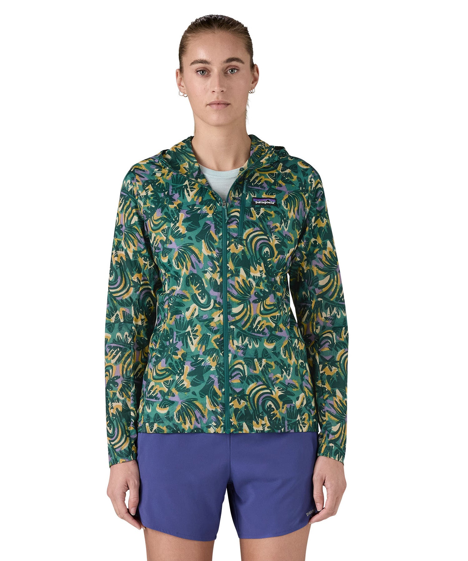 Patagonia women's houdini jacket in a turquoise colour with a retro flower design worn by a woman front detail