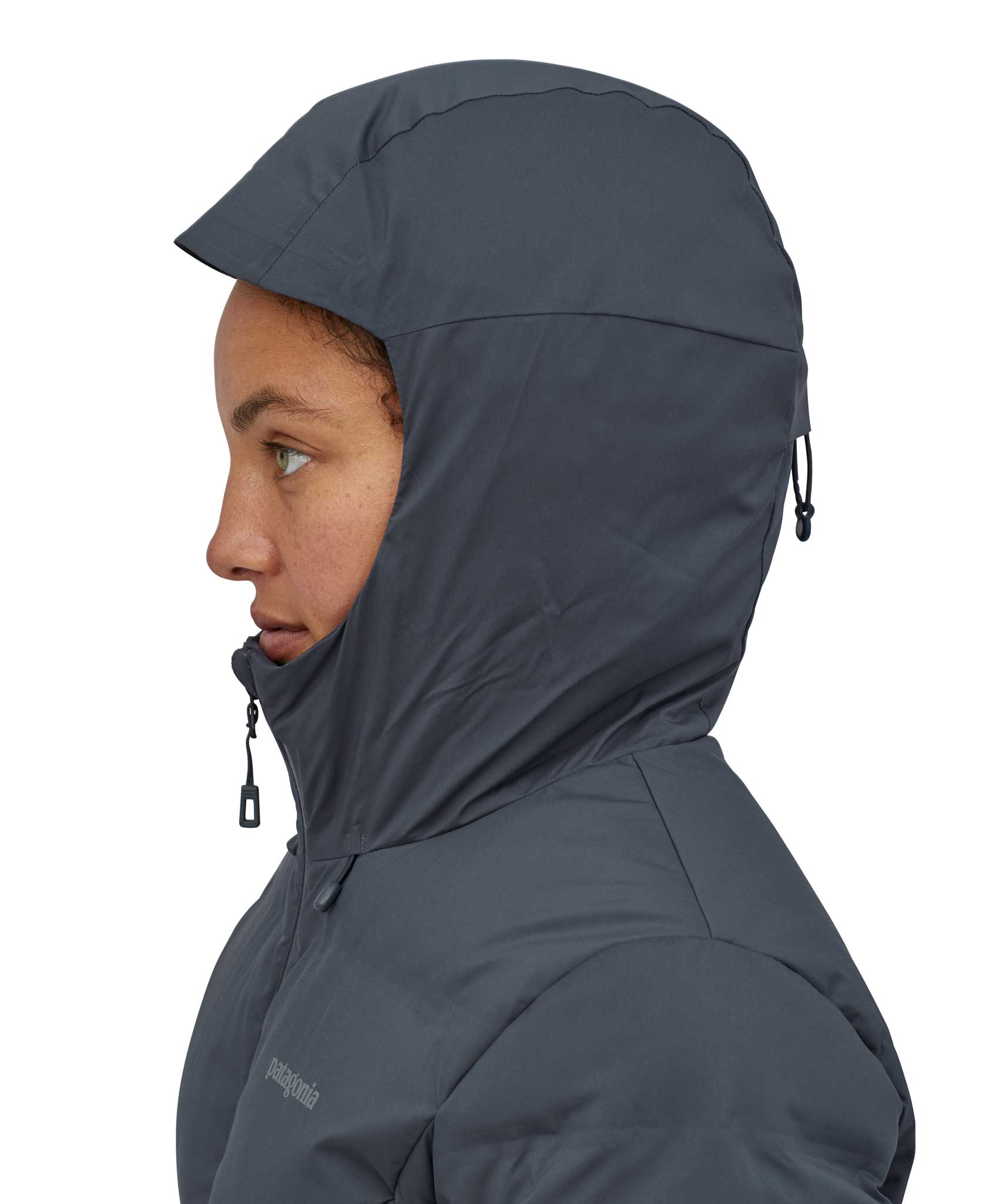 A close up of a woman wearing the hood of the Patagonia Women's Jackson Glacier Jacket in a Smolder Blue colour up. 